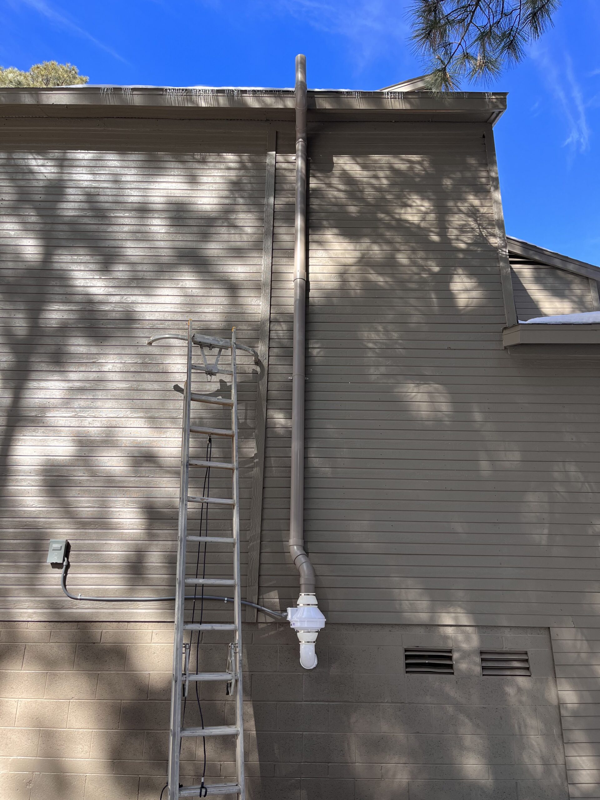 Painted radon system on the side of a home