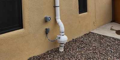 Radon fan constructued of pvc pipe installed on the side of a home in phoenix.